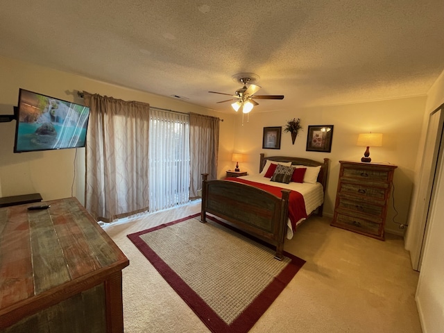 carpeted bedroom with ceiling fan and a textured ceiling