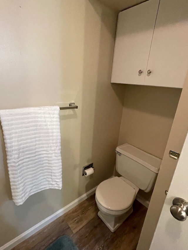 bathroom with hardwood / wood-style flooring and toilet