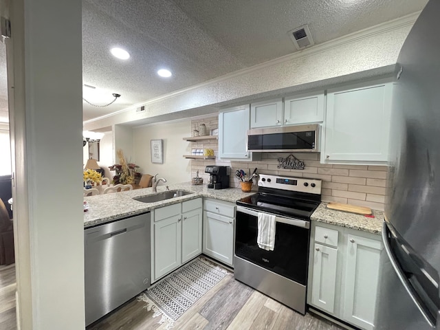 kitchen with white cabinets, a textured ceiling, and stainless steel appliances