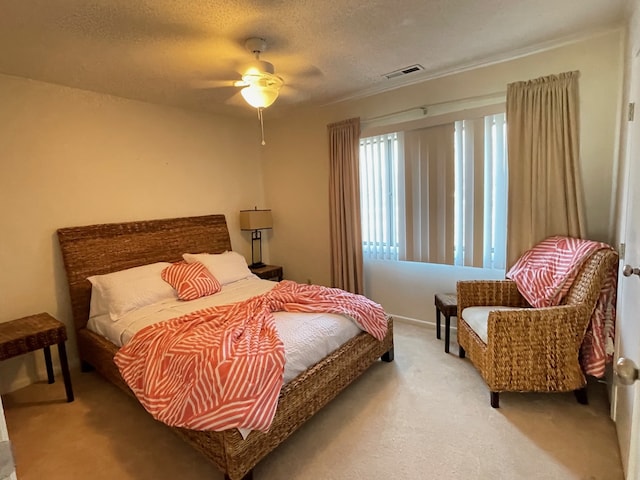 carpeted bedroom with ceiling fan and a textured ceiling