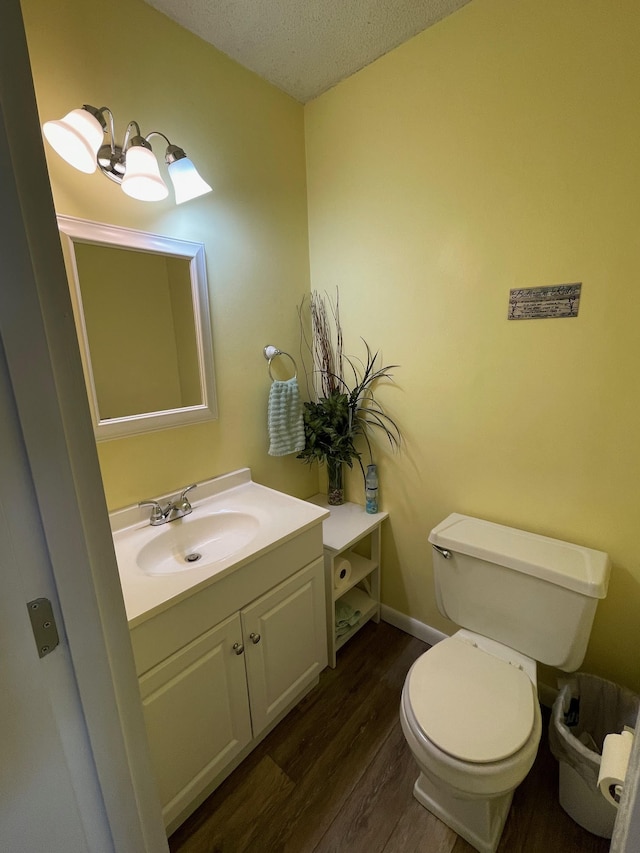 bathroom featuring hardwood / wood-style floors, vanity, a textured ceiling, and toilet