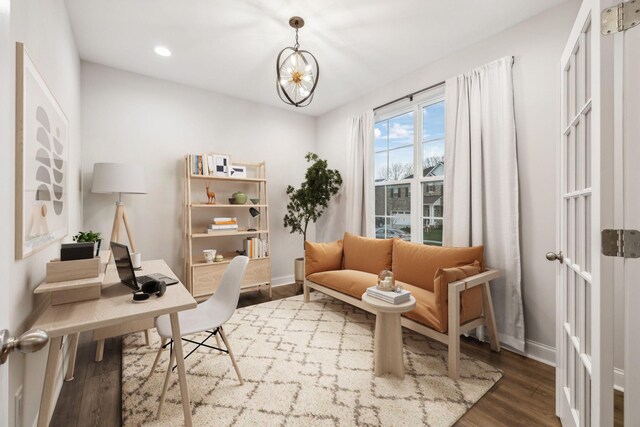 sitting room with hardwood / wood-style floors and a notable chandelier