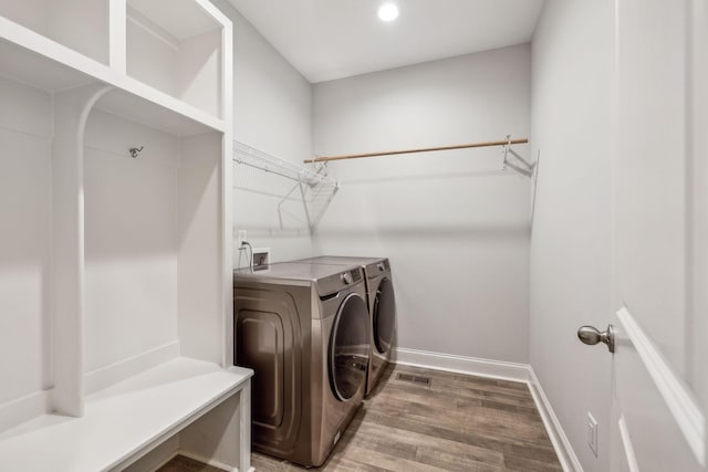 clothes washing area featuring hardwood / wood-style flooring and washing machine and dryer