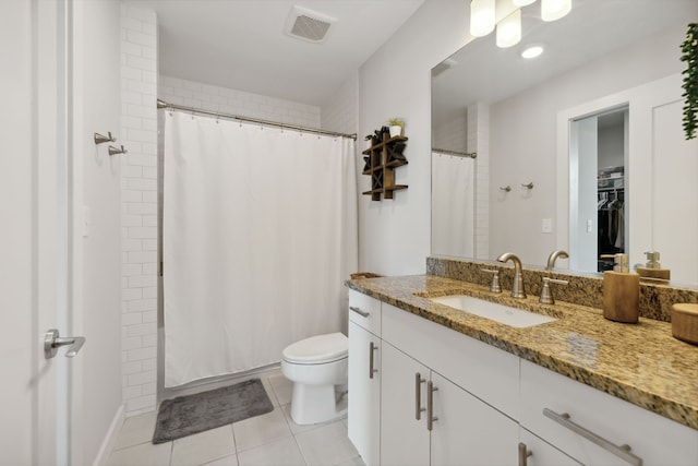 bathroom featuring tile patterned flooring, vanity, toilet, and walk in shower