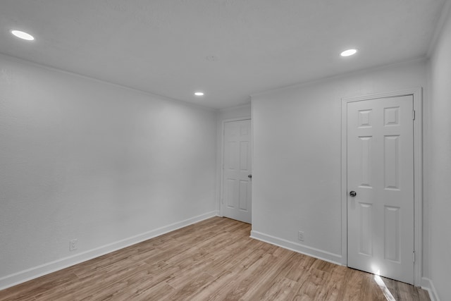 empty room featuring light hardwood / wood-style flooring and crown molding