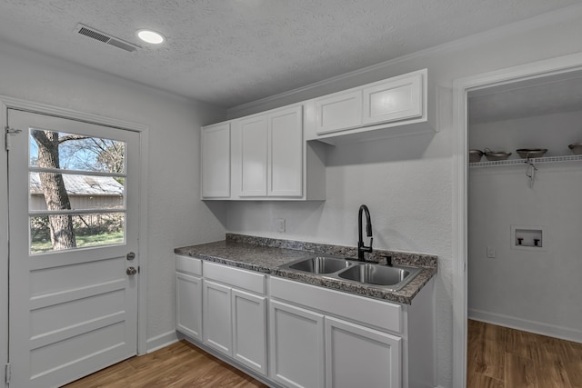 kitchen with white cabinetry, sink, dark hardwood / wood-style flooring, and a textured ceiling