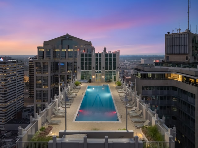 pool at dusk featuring a patio