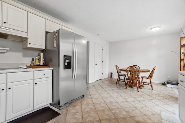 kitchen with stainless steel fridge, black electric stovetop, and white cabinets