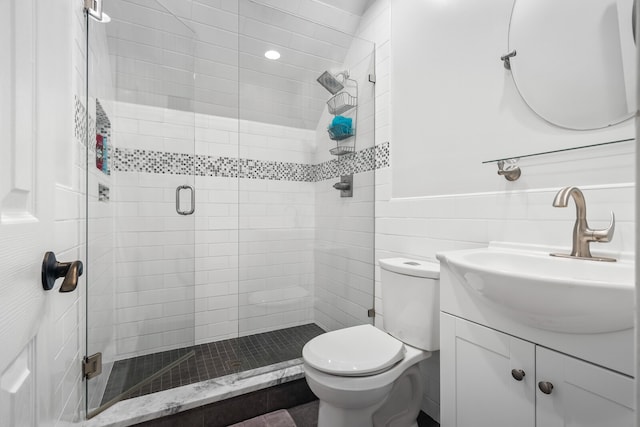 bathroom featuring an enclosed shower, vanity, toilet, and tile walls