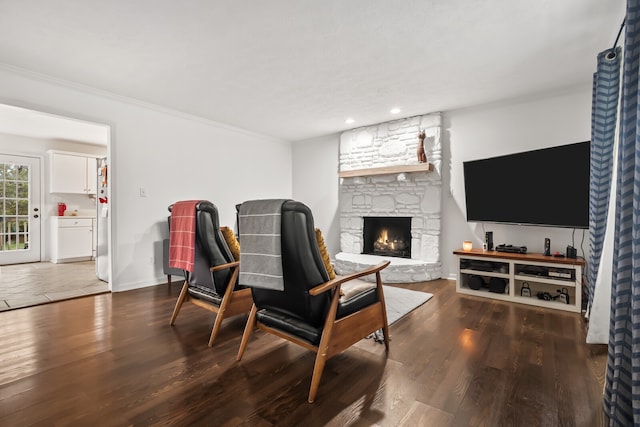 living room featuring a fireplace, crown molding, and dark hardwood / wood-style floors