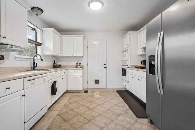 kitchen with a textured ceiling, white appliances, white cabinetry, and sink