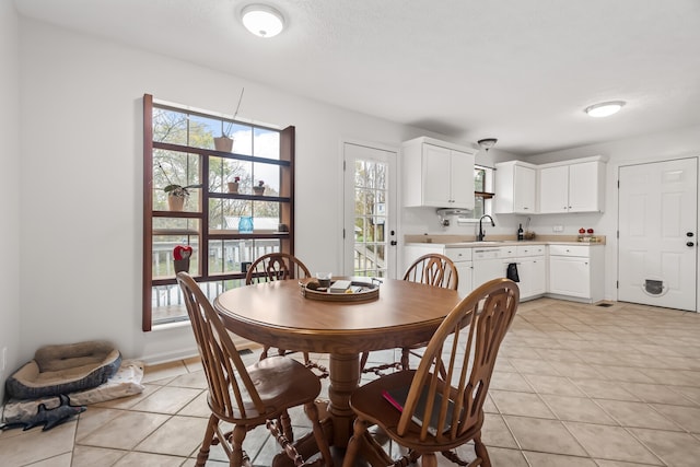 dining space featuring sink and light tile patterned flooring