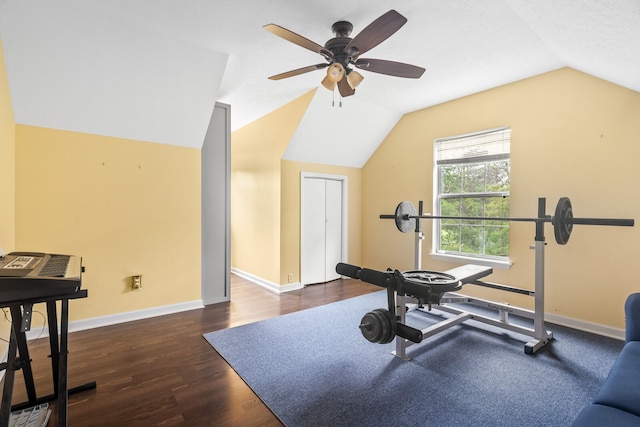 workout area with ceiling fan, dark wood-type flooring, and vaulted ceiling