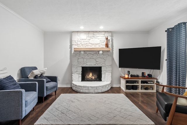 living room featuring a stone fireplace, dark wood-type flooring, and ornamental molding