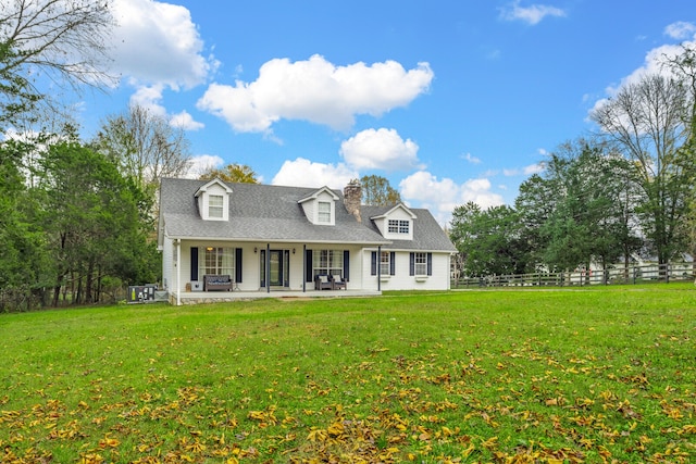 cape cod-style house featuring a front yard and covered porch