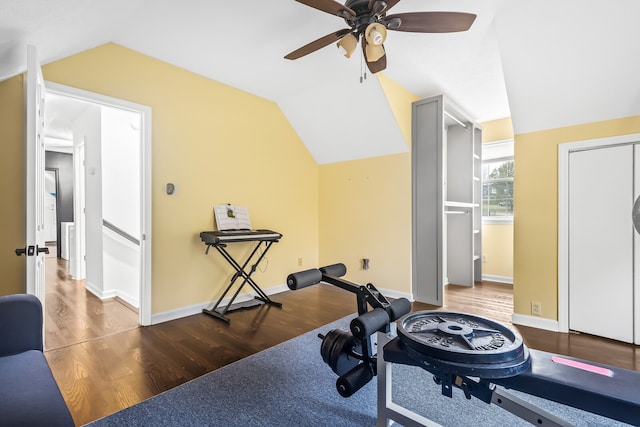 exercise room with ceiling fan, dark hardwood / wood-style flooring, and lofted ceiling