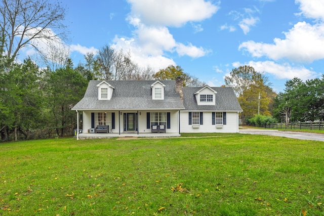 cape cod house featuring covered porch and a front yard