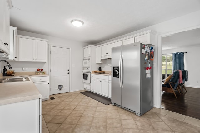 kitchen with sink, white cabinets, white appliances, and light wood-type flooring