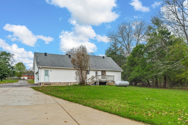 back of property with a lawn, a garage, and a deck