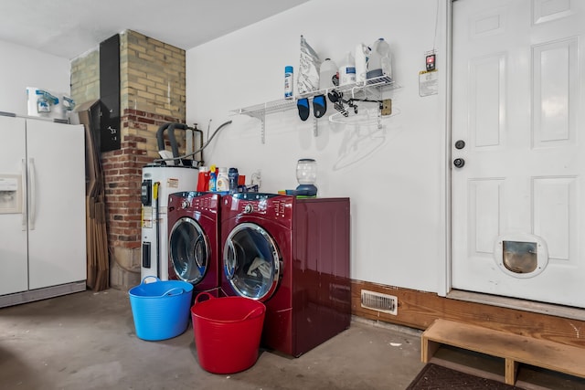 laundry area with washing machine and dryer and water heater