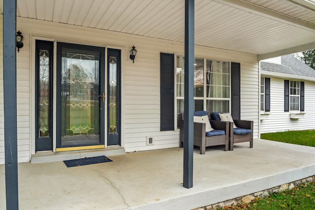 view of exterior entry featuring covered porch