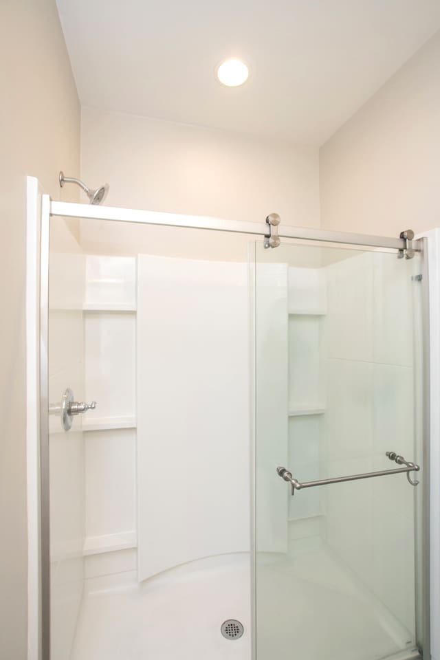 bathroom featuring a shower with door