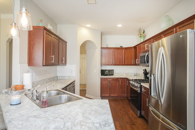 kitchen with sink, tasteful backsplash, dark hardwood / wood-style floors, decorative light fixtures, and appliances with stainless steel finishes