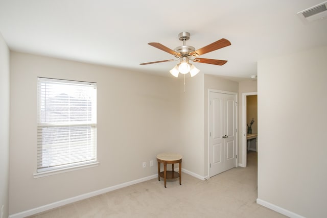 spare room featuring light carpet and ceiling fan