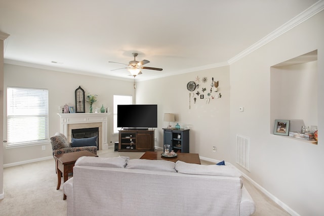 carpeted living room with a fireplace, ceiling fan, and crown molding