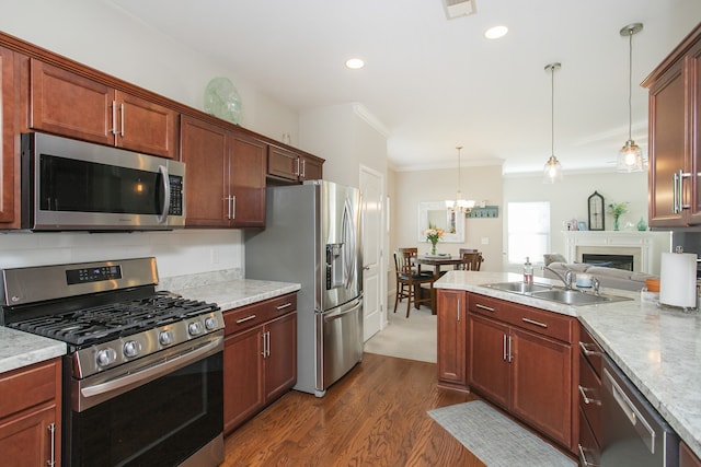 kitchen featuring sink, pendant lighting, dark wood-type flooring, crown molding, and stainless steel appliances