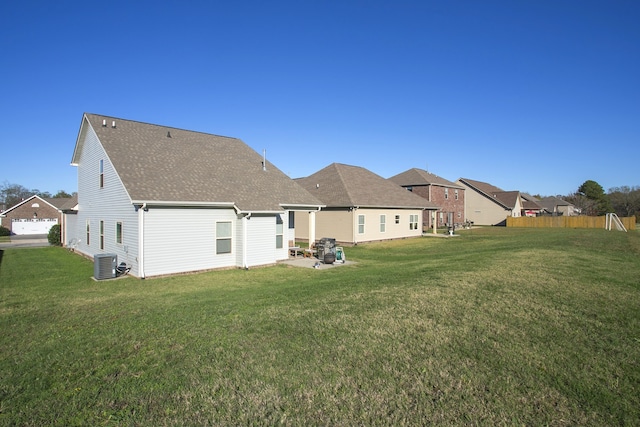 back of house with cooling unit, a patio area, and a lawn