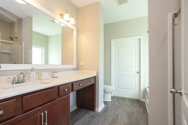 bathroom with vanity, toilet, and walk in shower