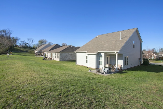 rear view of property featuring a patio area and a lawn