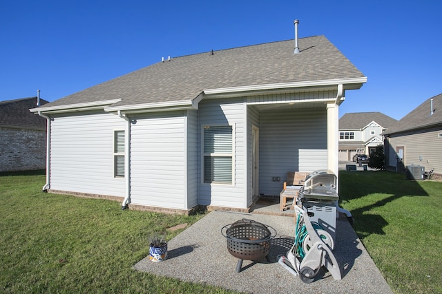 back of house featuring a lawn and a fire pit