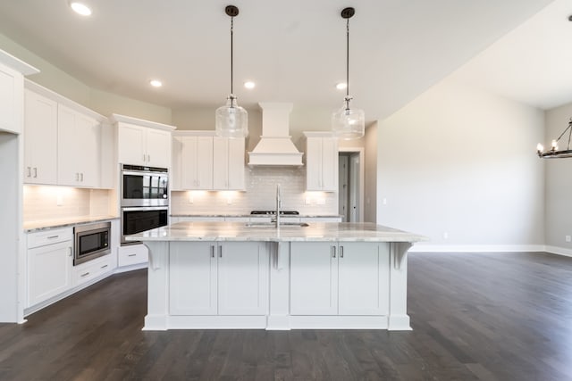 kitchen with dark hardwood / wood-style flooring, custom exhaust hood, stainless steel appliances, decorative light fixtures, and white cabinets