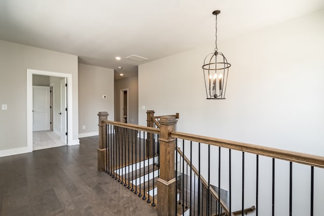 hall with dark hardwood / wood-style flooring and a chandelier