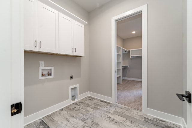 washroom with washer hookup, cabinets, light wood-type flooring, and hookup for an electric dryer