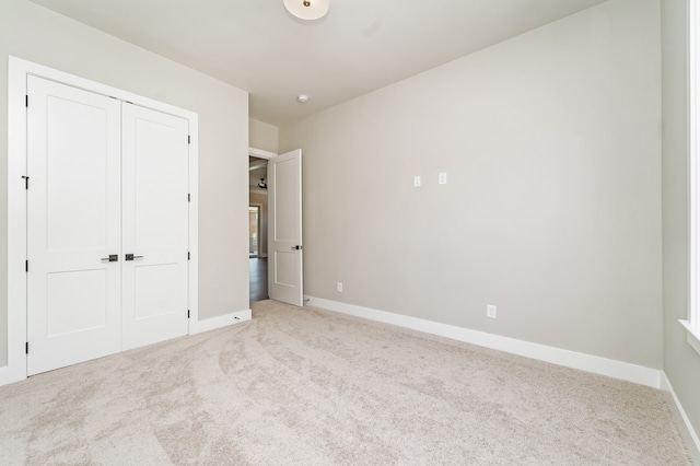 unfurnished bedroom with a closet and light carpet