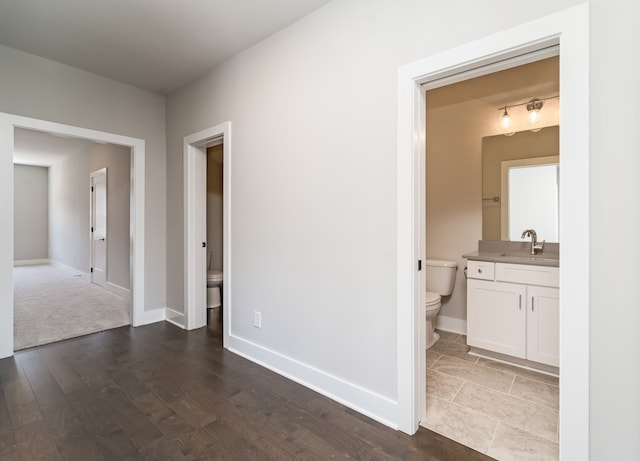 hallway featuring sink and hardwood / wood-style flooring