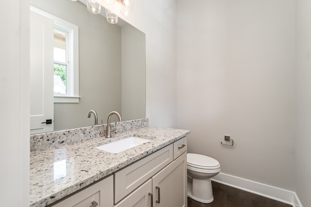 bathroom featuring wood-type flooring, vanity, and toilet