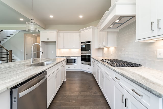 kitchen featuring premium range hood, stainless steel appliances, dark wood-type flooring, sink, and white cabinets