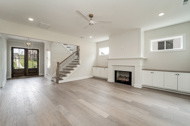 unfurnished living room with ceiling fan, crown molding, and light wood-type flooring