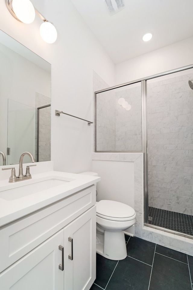 bathroom featuring tile patterned flooring, vanity, an enclosed shower, and toilet