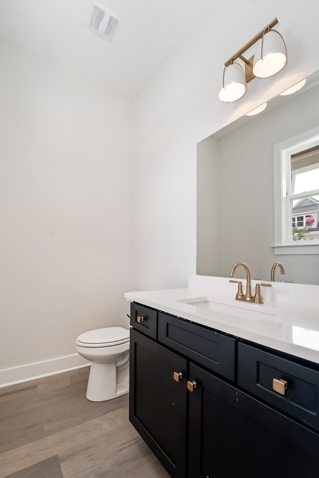 bathroom featuring vanity, toilet, and wood-type flooring