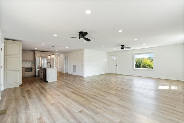 unfurnished living room featuring light hardwood / wood-style flooring and ceiling fan