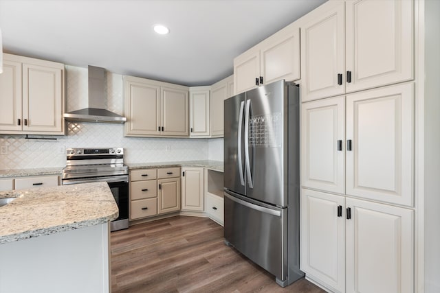 kitchen with decorative backsplash, dark hardwood / wood-style flooring, wall chimney range hood, stainless steel appliances, and light stone counters