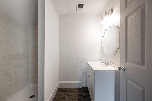 800 Tunnel Blvd, Chattanooga, TN 37406 - bathroom featuring vanity, wood finished floors, vaulted ceiling, baseboards, and tiled shower