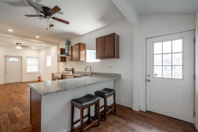 800 Tunnel Blvd, Chattanooga, TN 37406 - kitchen with electric range, a sink, a ceiling fan, a breakfast bar area, and wall chimney range hood