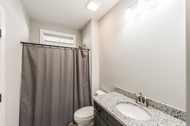 bathroom with vanity, a shower with shower curtain, and toilet