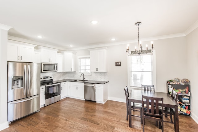 kitchen with dark hardwood / wood-style floors, stainless steel appliances, plenty of natural light, and sink